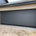 Sicherheit garagentore berlin: RC 2 & normen für gewerbe 3 Moderne graue Garagentorfront in neuem Gebäude, umgeben von hellem Putz. Perfekt für stilvolle Architekturideen.